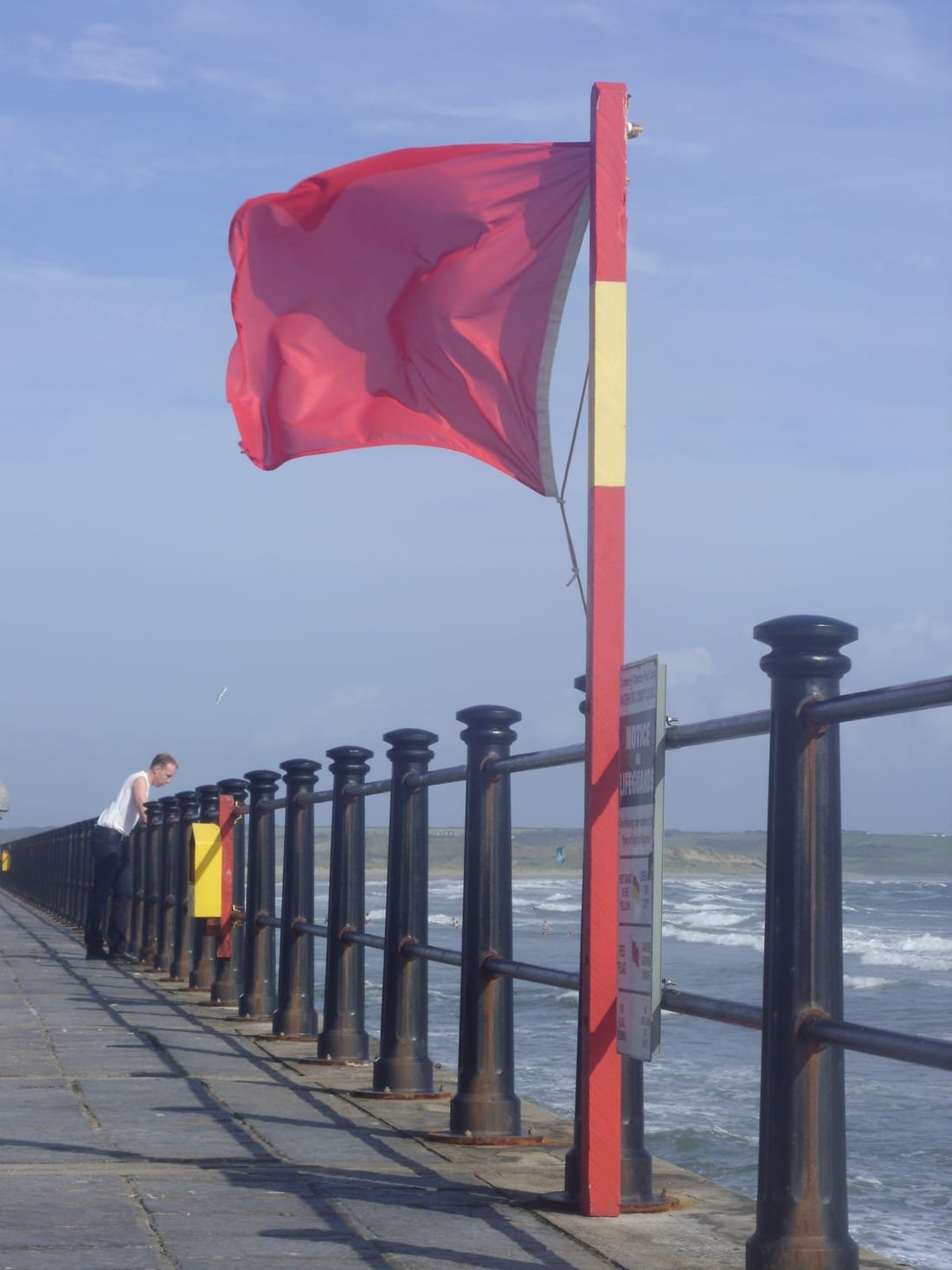 Bandera roja de baño prohibido ondeando en una playa