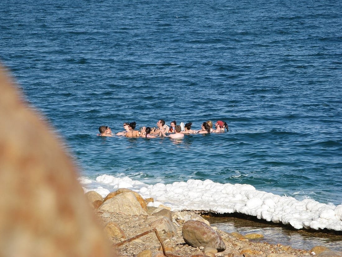 Grupo de personas flotando en el mar; ejemplo visual de cómo flotar en el mar sin esfuerzo