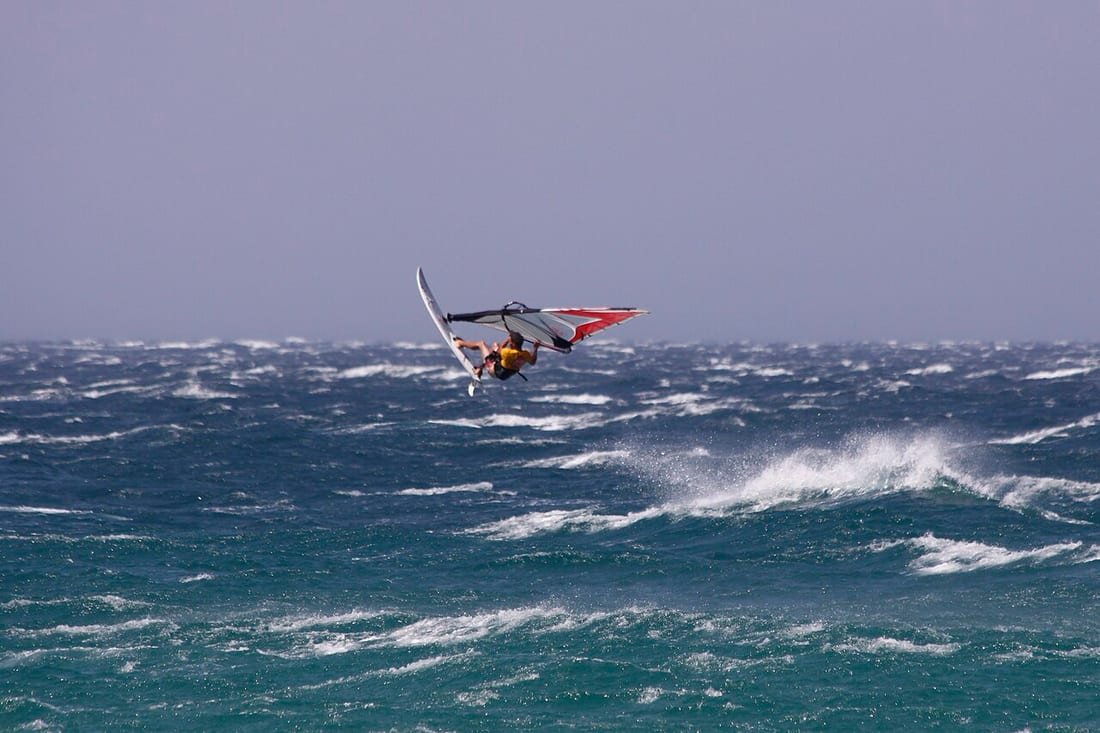 Windsurfista saltando con viento fuerte y mar picada frente a Tarifa, en el Estrecho