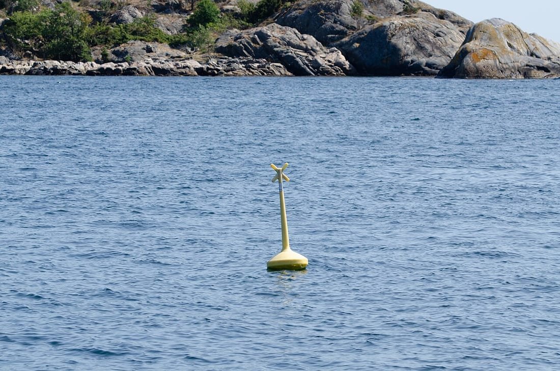 Boya amarilla de seguridad fondeada en el mar, del tipo que separa la zona de baño del paso de embarcaciones
