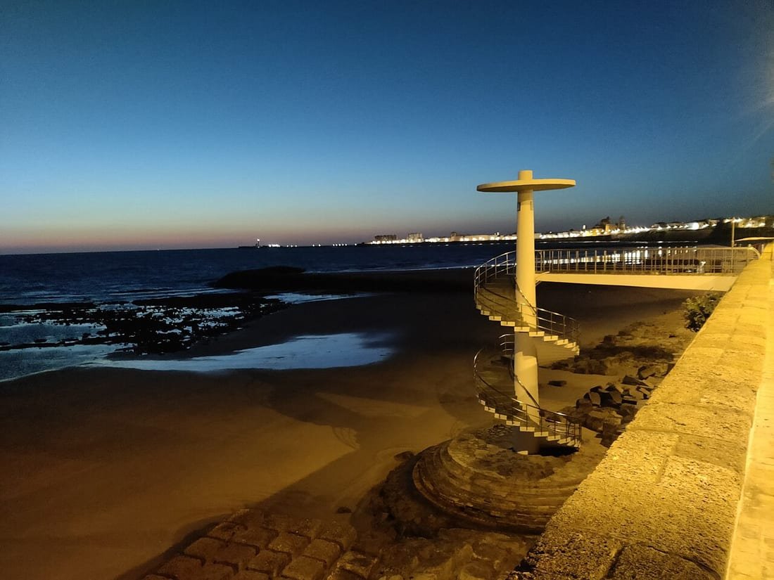 Escalera de caracol de acceso público a la playa de Santa María del Mar, en Cádiz, al anochecer